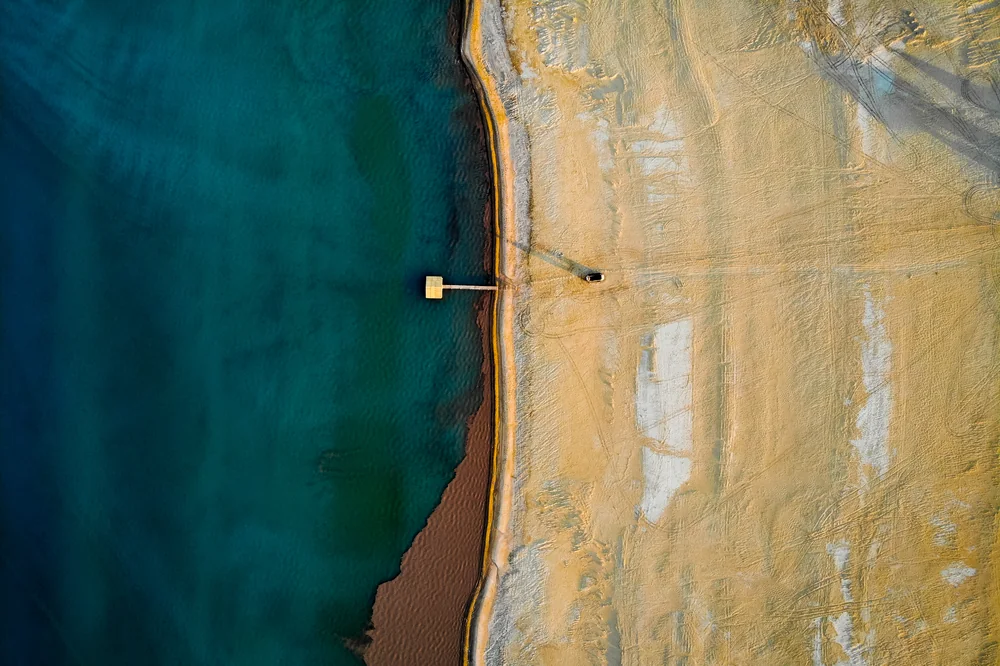 The turquoise water of the Aral Sea meeting the sandy shore
