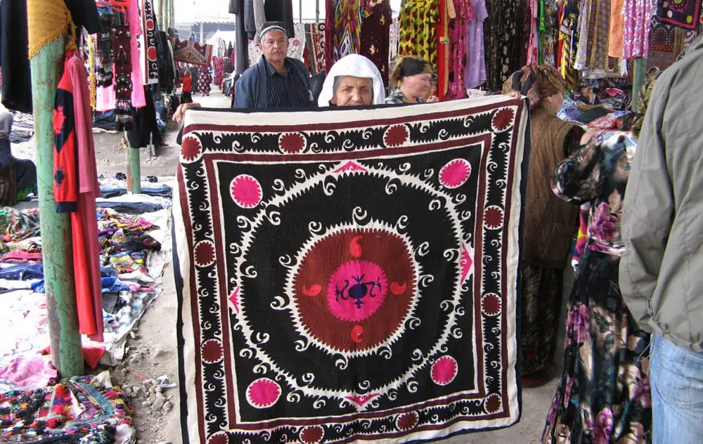Commerçants présentant un suzani au bazar d'Ourghout