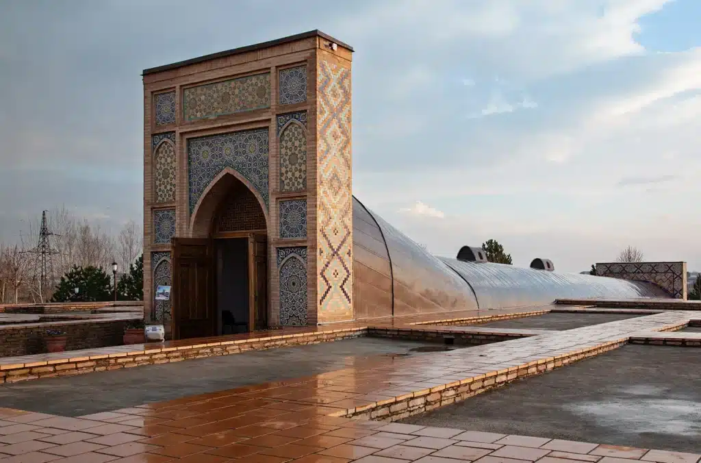 Modern-day entrance to the Ulugh Beg Observatory in Samarkand, featuring restored tiled archway and the long roof covering the underground sextant
